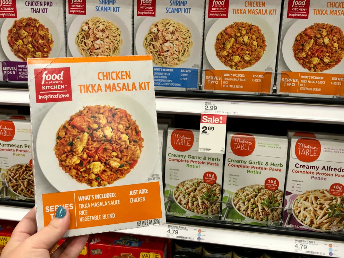 hand holding box of food by store display