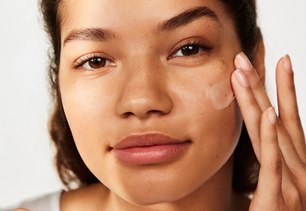 woman putting cream on her face