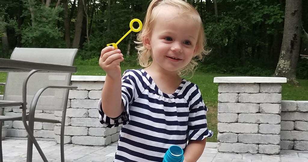 young girl with bubble wand and jar