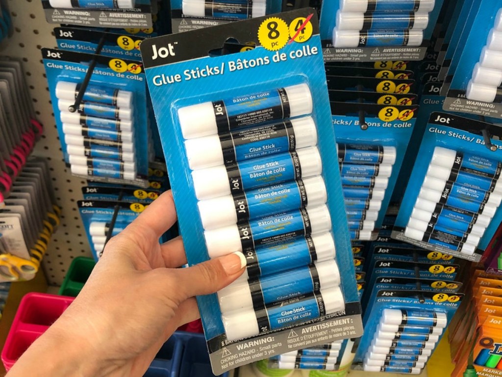 hand holding large pack of glue sticks