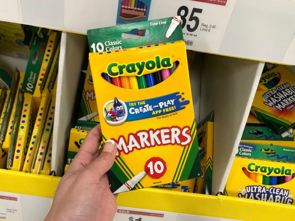 Crayola Markers held up in front of school supply bin