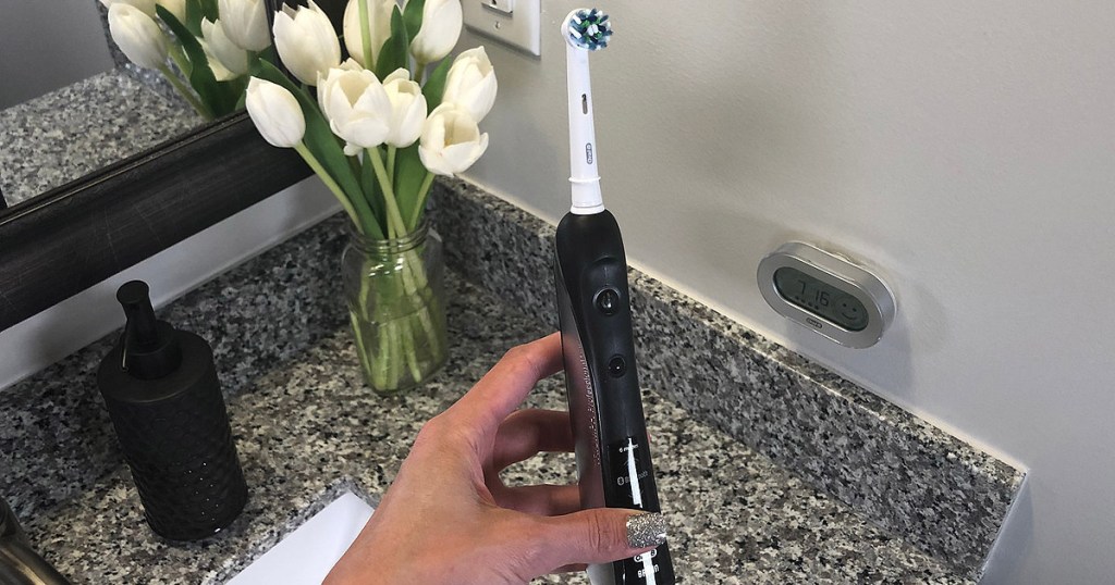 oral b toothbrush 7000 by a sink held by hand