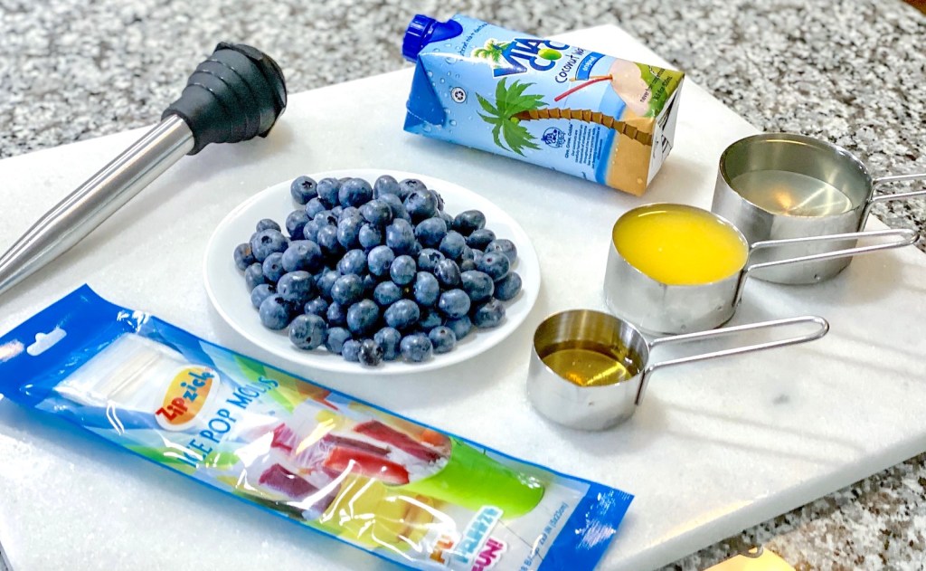 fresh blueberries and measuring cups with various liquids inside