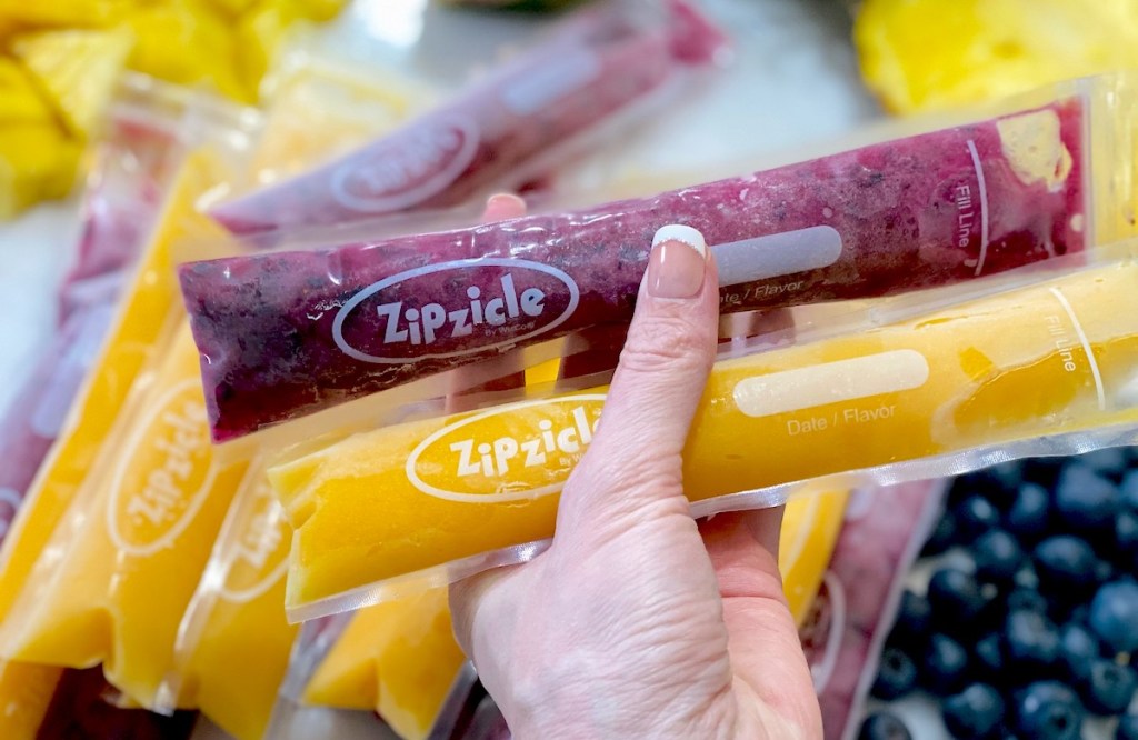 hand holding a purple and orange frozen popsicle