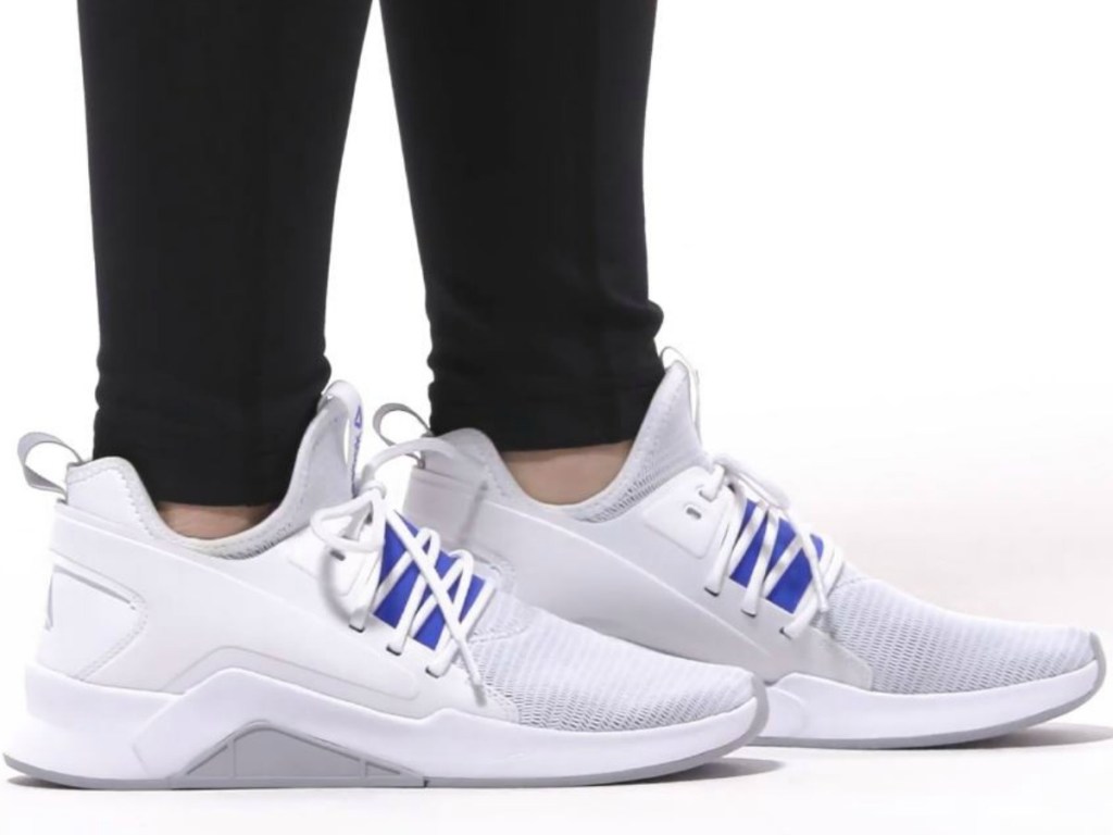 feet wearing white shoes and black leggings
