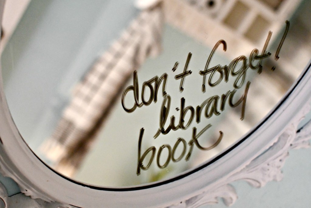 library book reminder written on bathroom mirror 