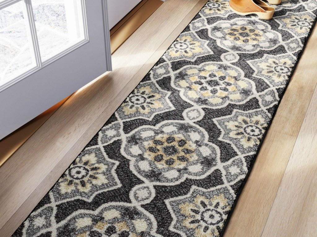 long rug by outside door with shoes on it