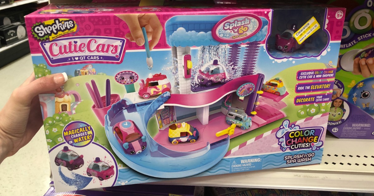 hand holding a shopkins cutie car set in front of a Target store shelf
