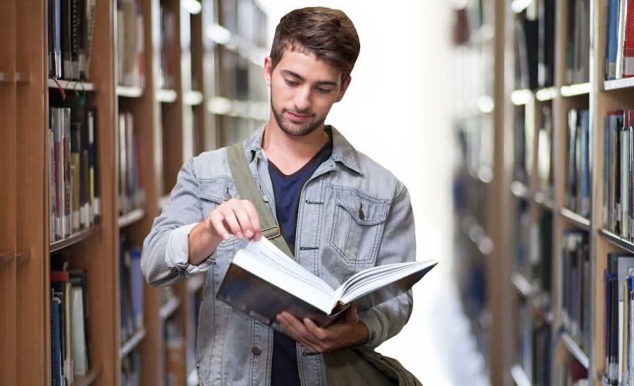 man at library reading book