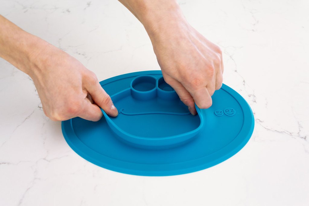 mom trying to pull up suctioned Sesame Street ezpz mat