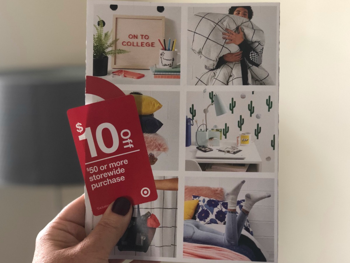 hand holding red coupon in front of mail