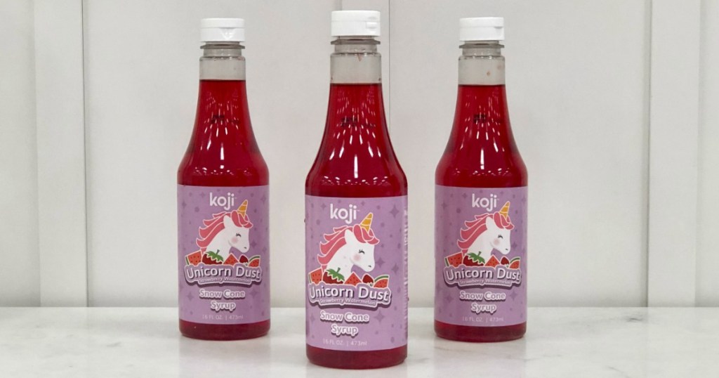 three bottles of red snow cone syrup on a table