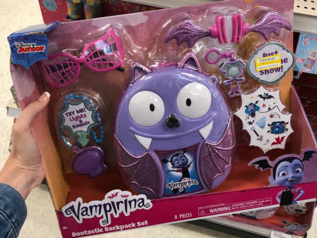 hand holding purple vampire toy in package at store