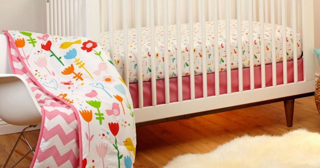 flowery crib blanket set with white nursery furniture