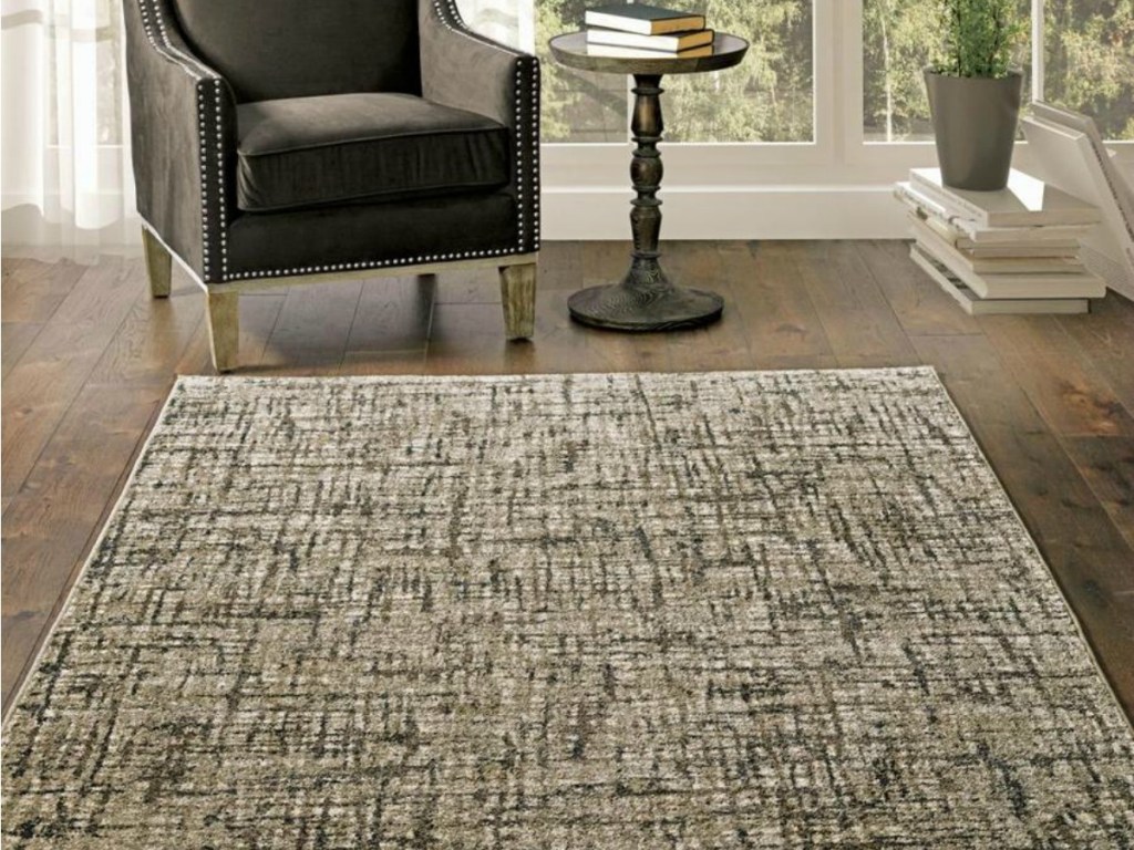 mutli-colored woven rug covering wooden floor