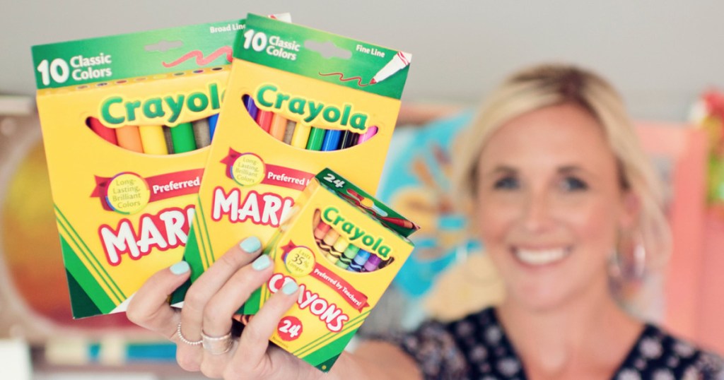 Woman holding crayola markers and crayons back to school