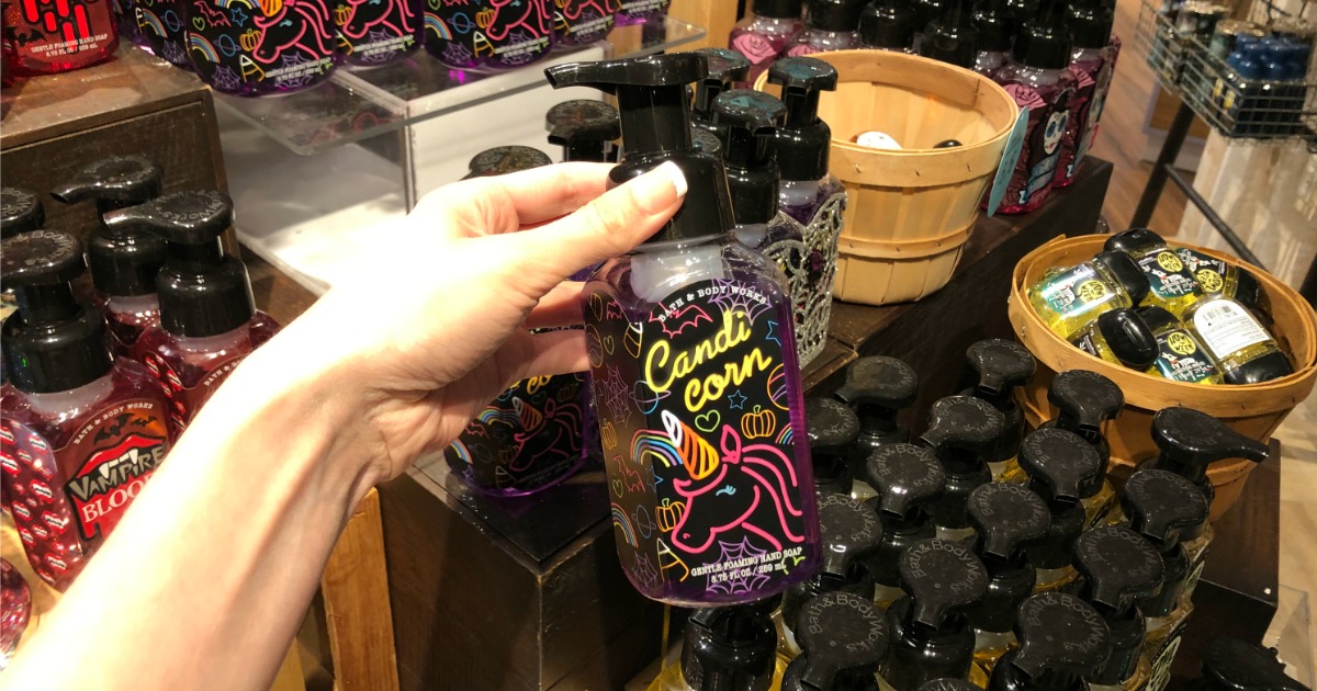 Woman holding bottle of Bath & Body Works Candi Corn Hand Soap