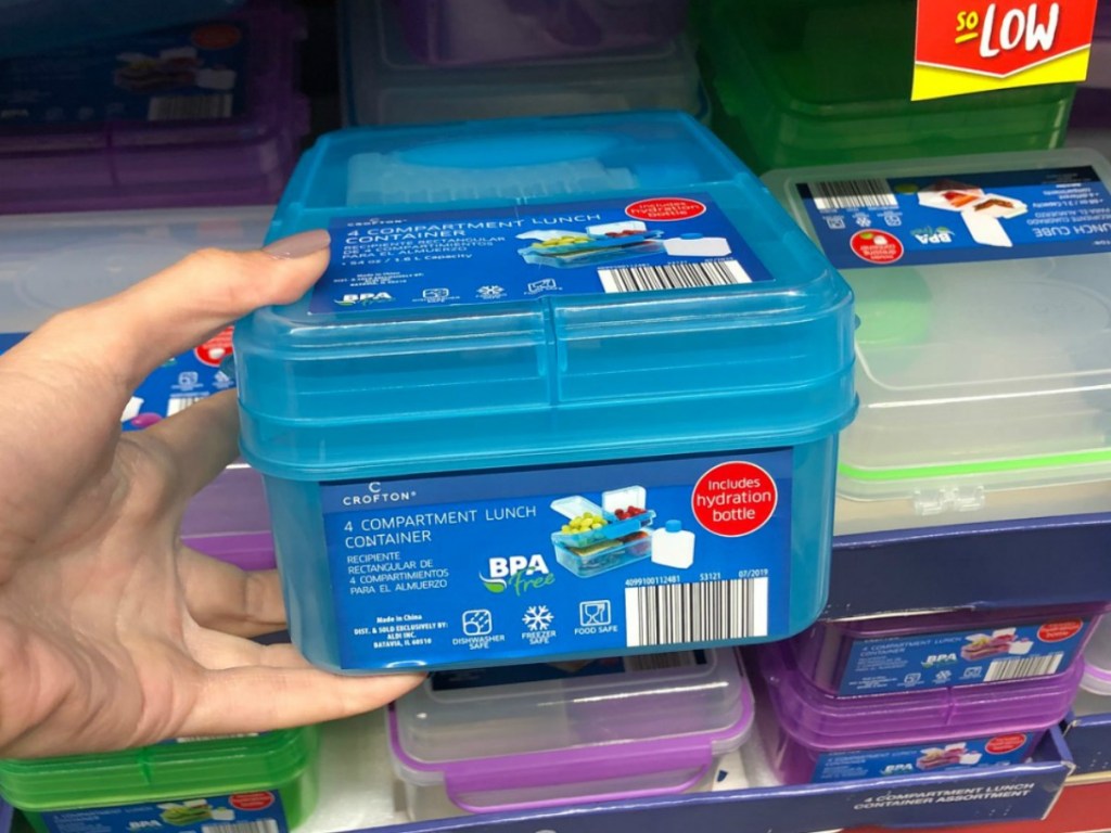 hand holding plastic lunch box by store display