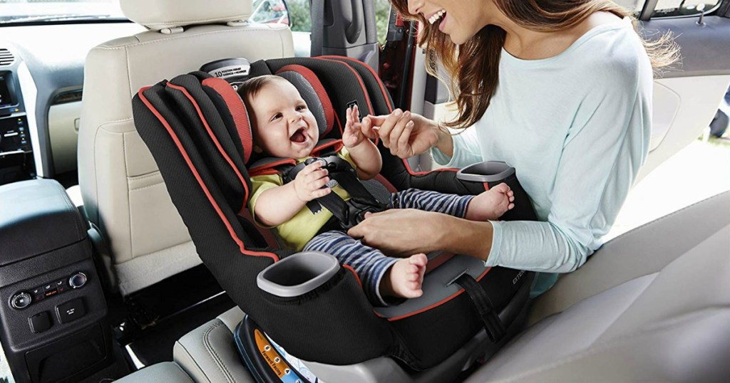 Woman fastening baby into Graco car seat