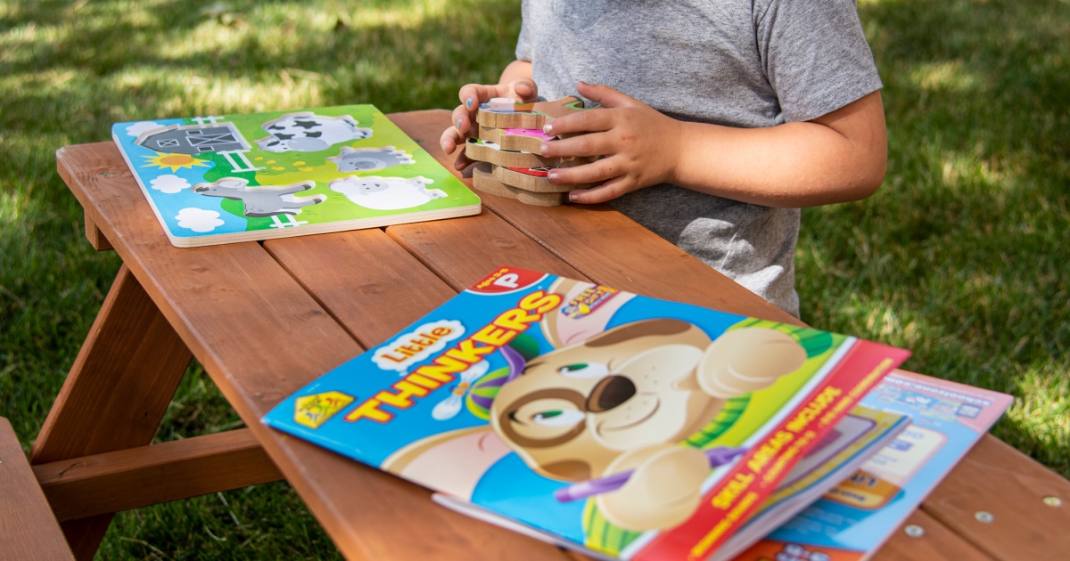 girl sitting at picnic table with books
