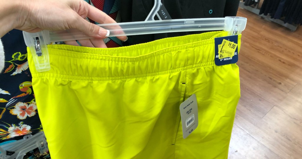 woman holding mens swim shorts at walmart