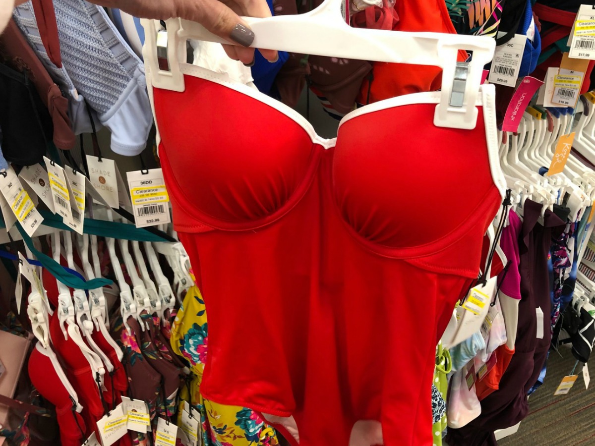 hand holding red swimsuit on hanger