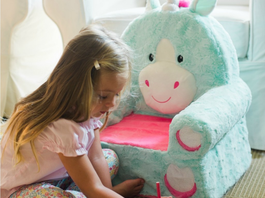 Girl drawing next to Sweet Seats Unicorn Chair