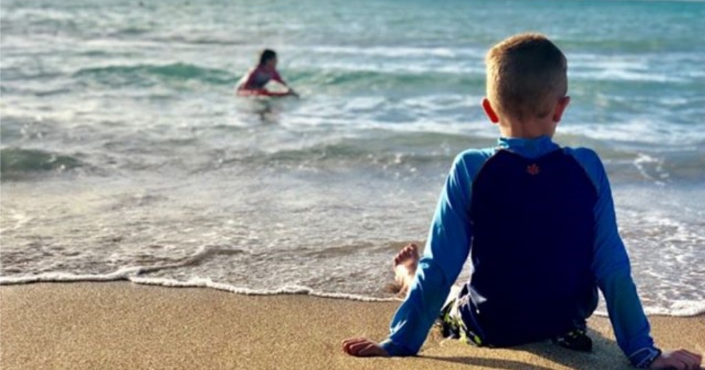 Boy on Beach wearing UV Skinz Boy's Rashguard