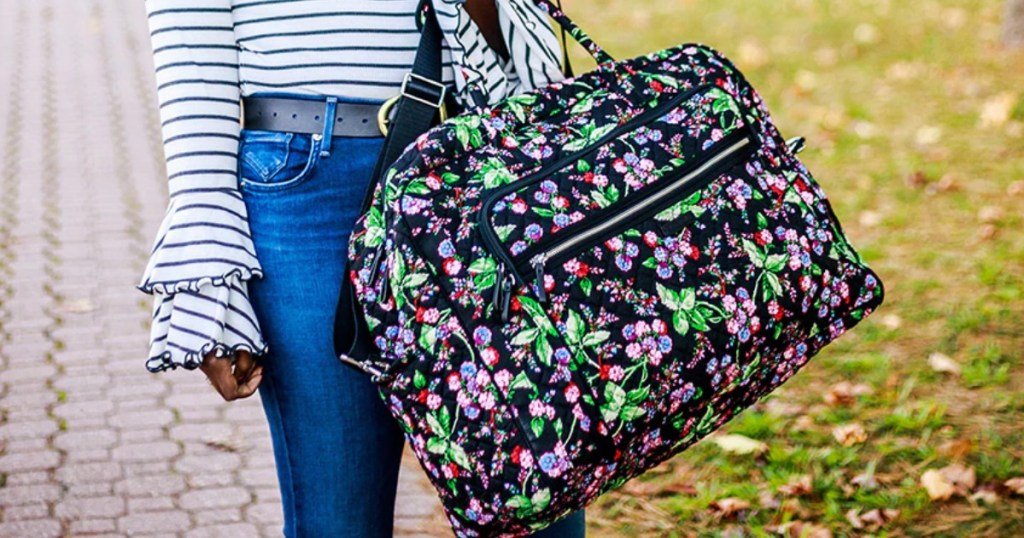 Vera Bradley Grand Weekender in Winterberry carried down sidewalk