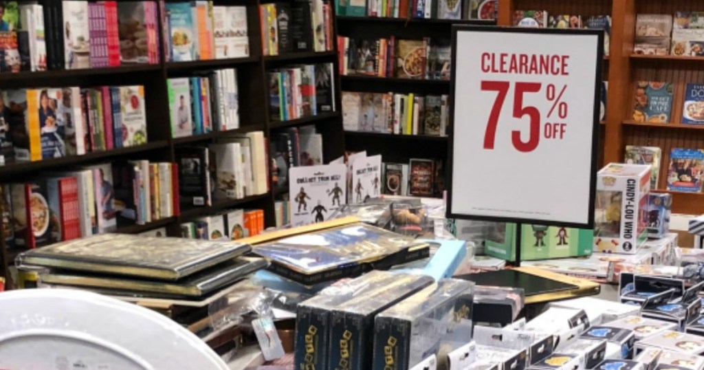 piles of books inside store by clearance sign