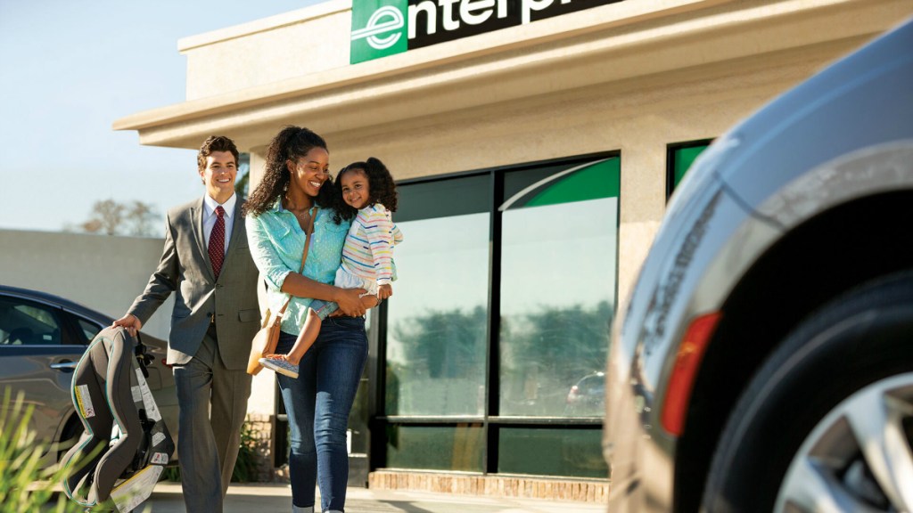 woman holding child walking to car