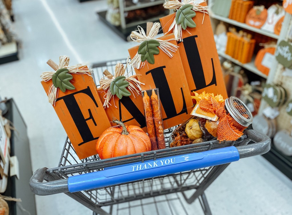 fall sign and various home decor in top of store cart