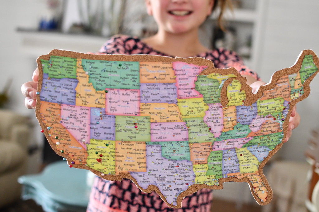little girl holding a map of the united states