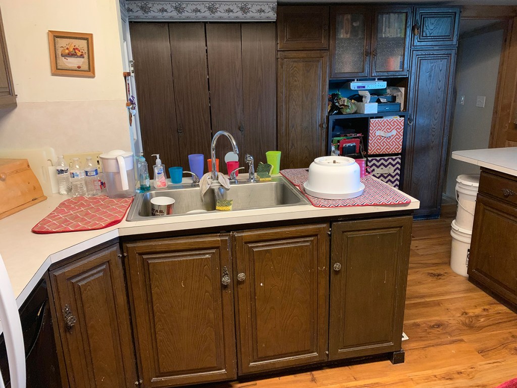 kitchen beforehand with brown cabinets and old countertop