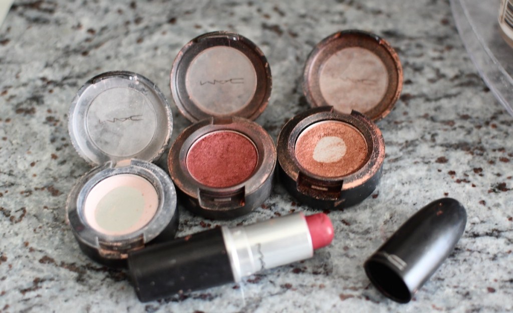 three MAC eyeshadows and pink lipstick on granite counter