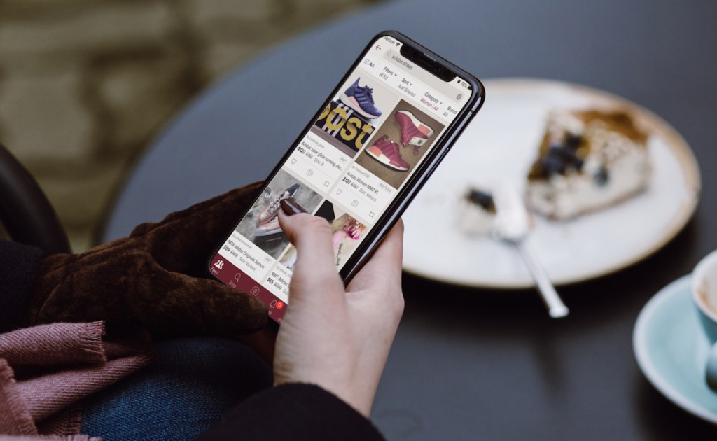 hand holding phone with poshmark on screen adidas deals