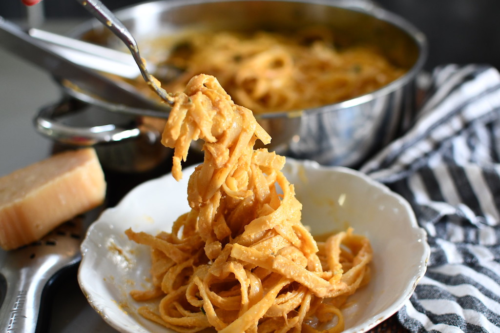 pumpkin alfredo in bowl with noodles being twirled on fork