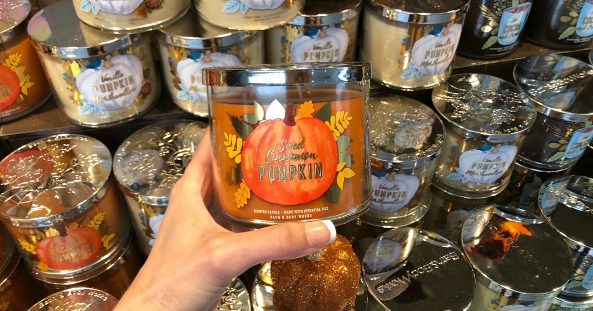 hand holding pumpkin candle