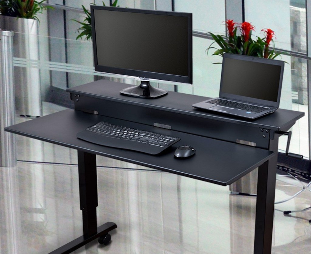 black standing desk with monitor and laptop