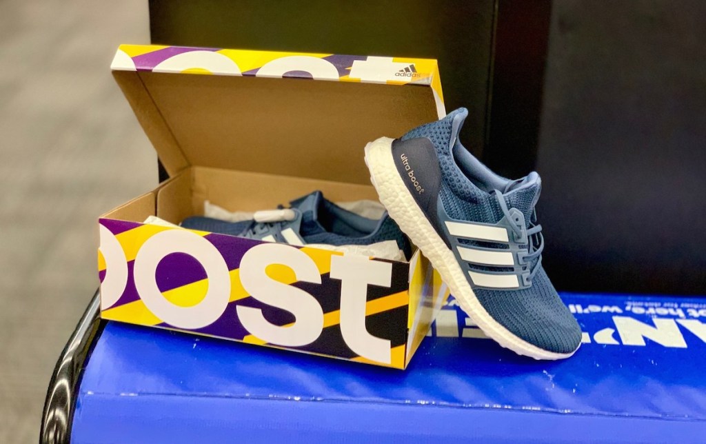 blue adidas sneakers and yellow box sitting on blue bench