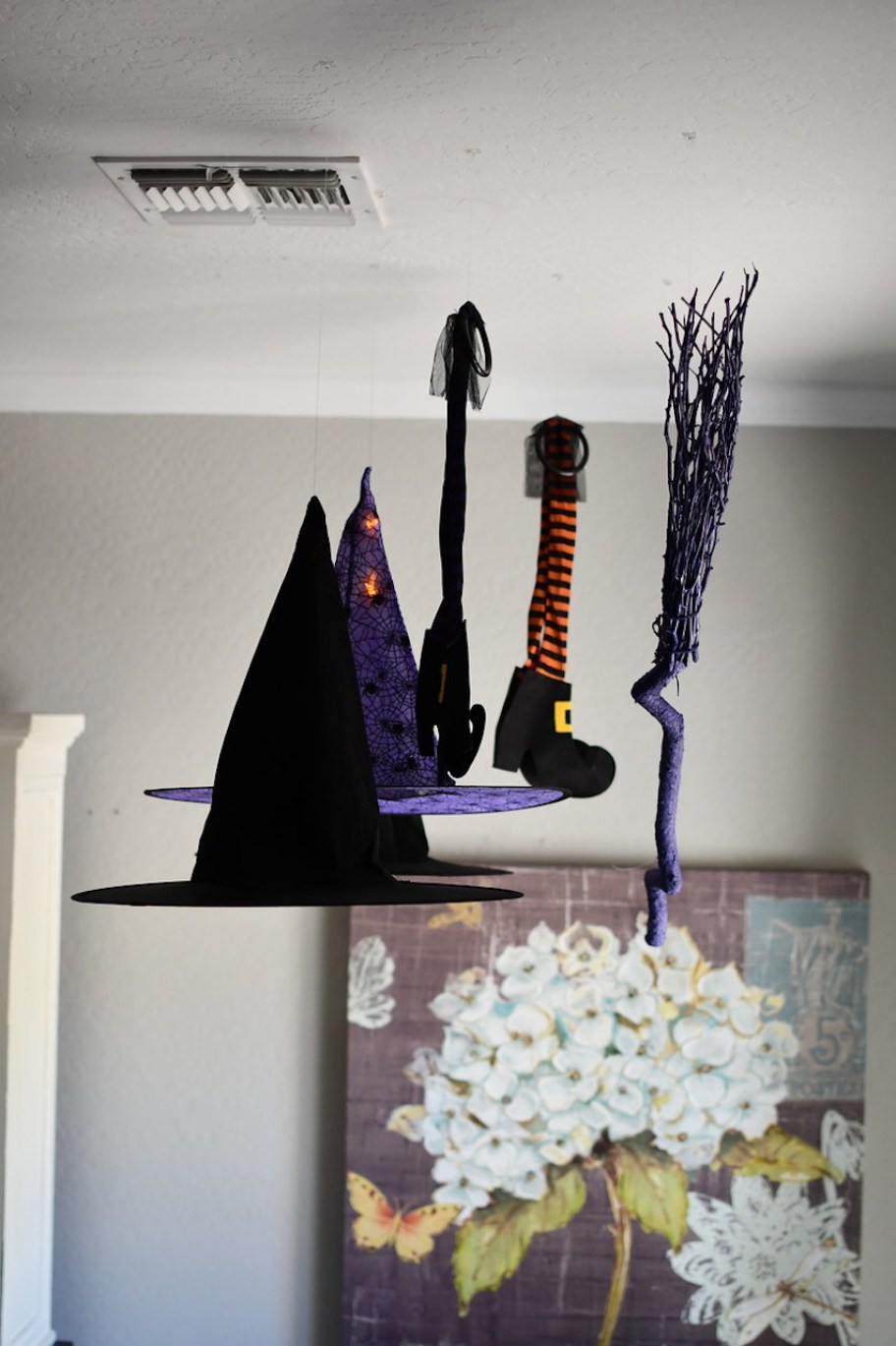 witch hats and broom hanging from ceiling