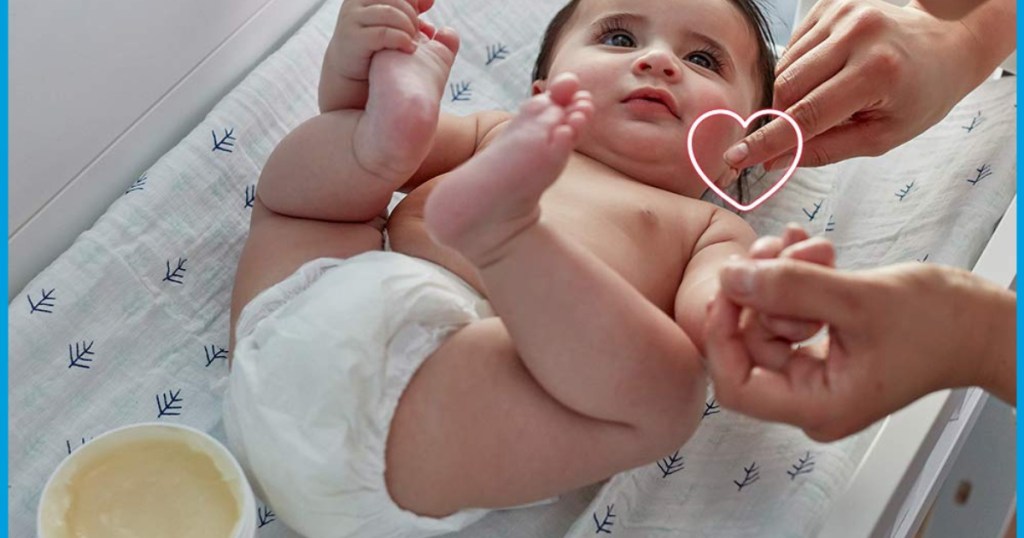 baby on changing table with aquaphor jar