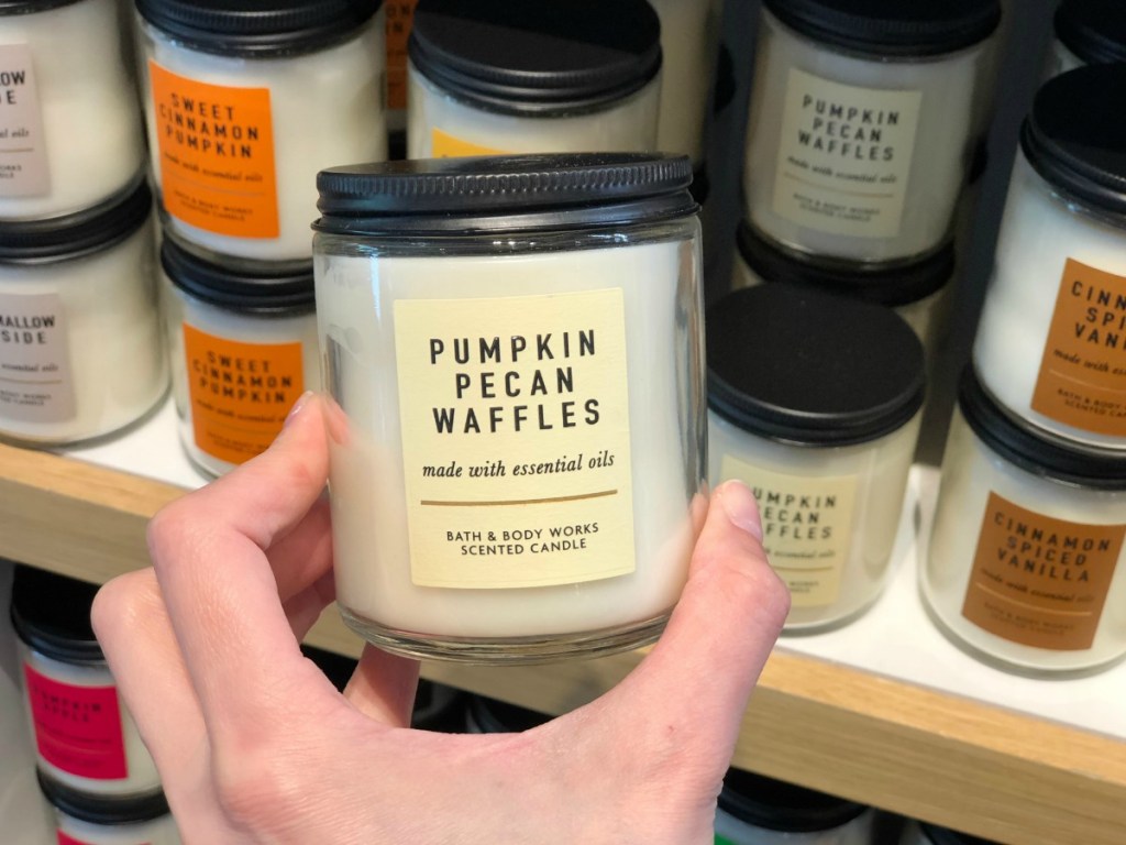 Holding a single wick fall scent candle in store at Bath & Body Works