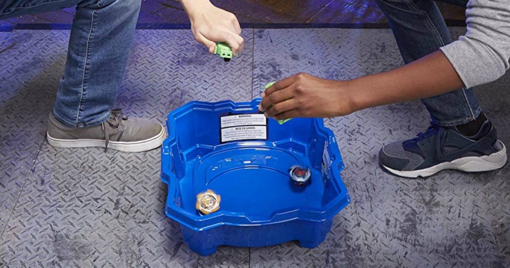 boys playing with Beyblade stadium