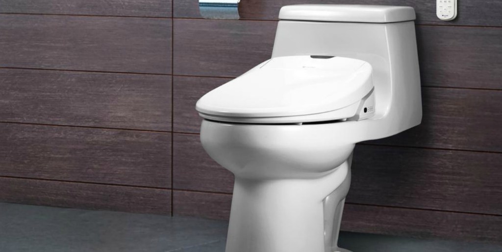 Electric bidet attached to a toilet in a bathroom