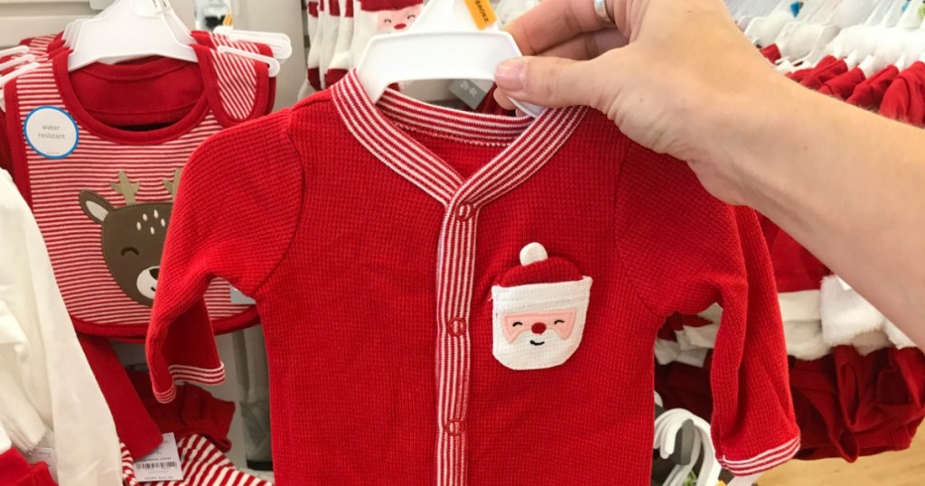 Woman holding Carter's Holiday Themed Pajamas in store