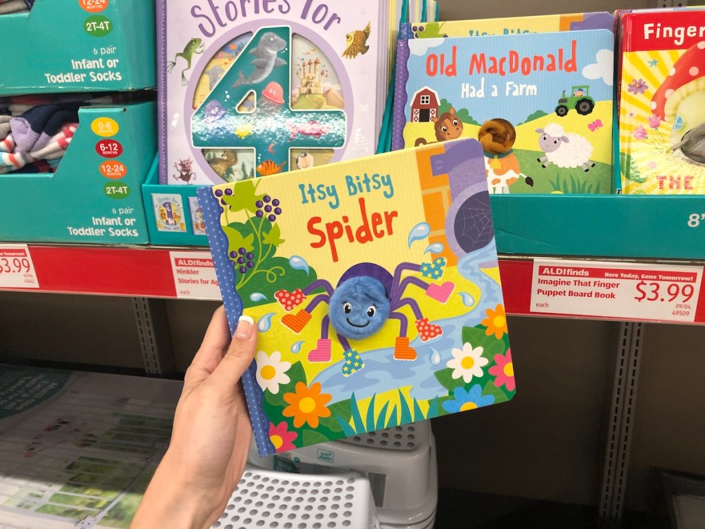 Woman holding Imagine That Finger Puppet Board Book in ALDI