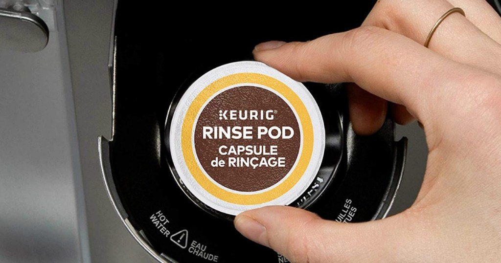Hand putting a rinse pod into a Keurig machine