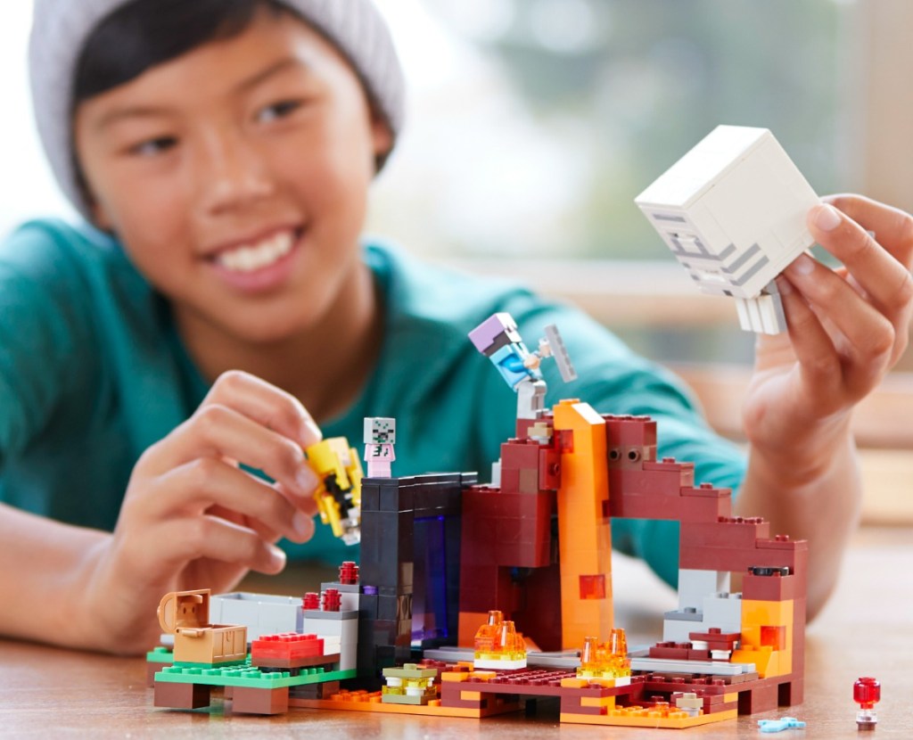 Kid playing with a LEGO Minecraft Set The Nether Portal Building kit