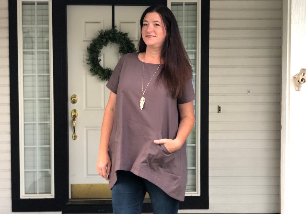 woman wearing purple gray top with leaf necklace outside